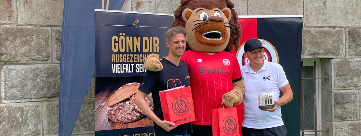 Kai Schröer, Maskottchen Taunas und Alf Mintzel gemeinsam beim Besuch der Riederbergschule