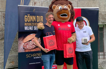 Kai Schröer, Maskottchen Taunas und Alf Mintzel beim Besuch der Riederbergschule